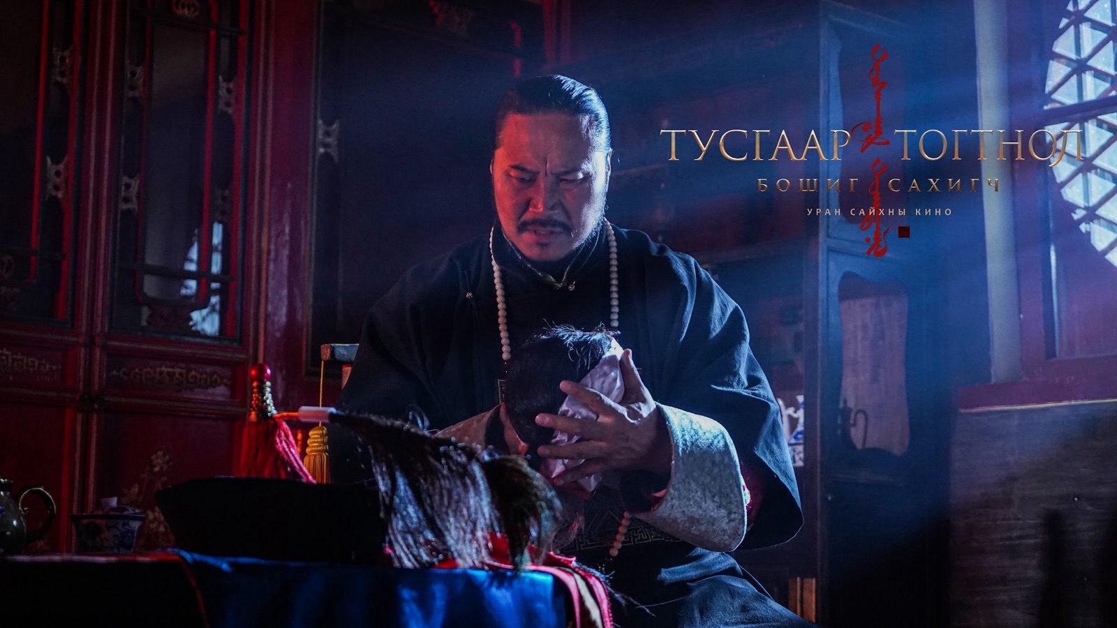 A man in a dark robe in a hall lit in blue